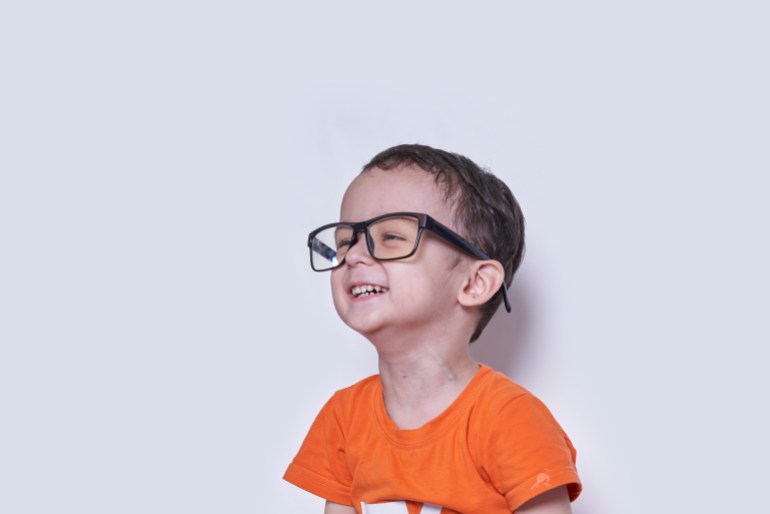 A cute little boy wearing big eyeglasses. Funny portrait of handsome 3-years-old multiracial kid. Cheerful child with big nerd eyeglasses كبير الرأس