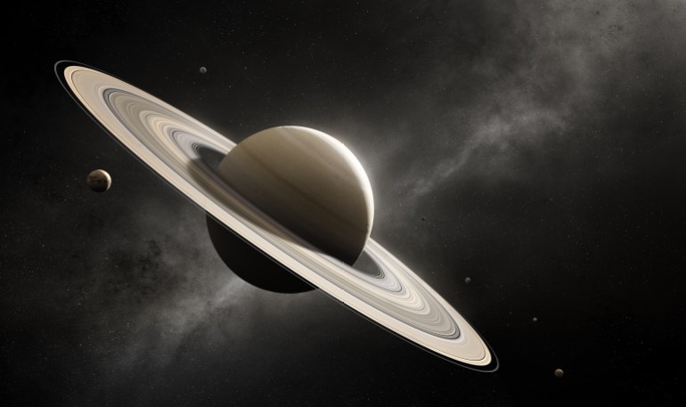 كوكب زحل - غيتي Planet Saturn in deep space with major moons according to scale (Elements of planet texture for 3d render furnished by NASA)