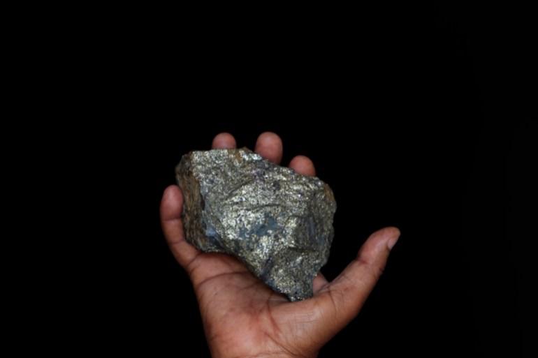 A mine employee shows a piece of copper ore at the Kilembe mines, in the foothills of the Rwenzori Mountains