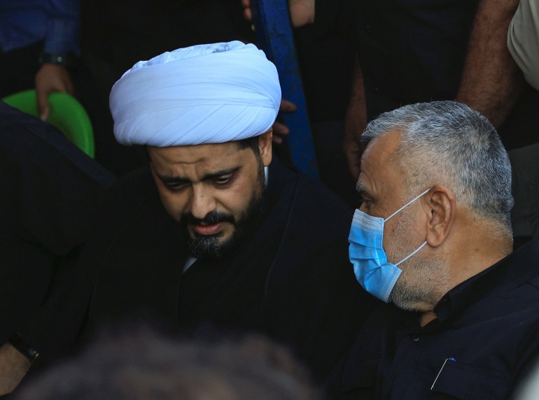 Qais al-Khazali, leader of Asaib Ahl al-Haq and Hadi al-Amiri, leader of the Badr Organisation, attend a symbolic funeral of supporters of Iraqi Shiite armed groups who were killed in a protest in Baghdad