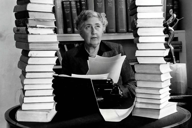 Mystery author and writer, Agatha Christie, pictured at her home, Winterbrook House in Wallingford, Berkshire, sitting behind her desk with books piled high, 1950. (Photo by Popperfoto via Getty Images/Getty Images)