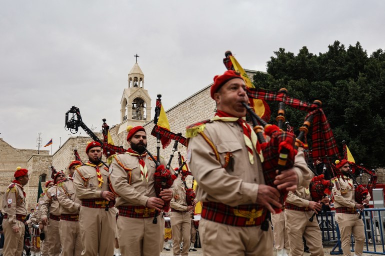 A Palestinian scouts band parades in front of the Church of the Nativity, revered as the site of Jesus Christ's birth, ahead of Christmas celebrations in the biblical city of Bethlehem in the Israeli occupied West Bank on December 24, 2021. (Photo by JAAFAR ASHTIYEH / AFP)