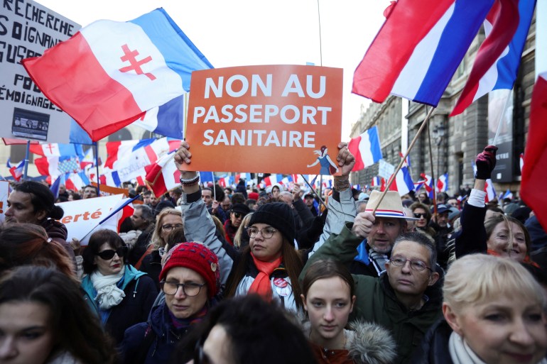 A demonstrator holds a placard that reads "No to the health passport" as people attend a demonstration called by French political party "Les Patriotes" against COVID-19 health pass as France sees an increase in coronavirus disease (COVID-19) cases and hospitalisations, in Paris, France, December 18, 2021. REUTERS/Sarah Meyssonnier 2021-12-18T163143Z_2140712963_RC21HR9DR0ZL_RTRMADP_3_HEALTH-CORONAVIRUS-FRANCE-PROTEST