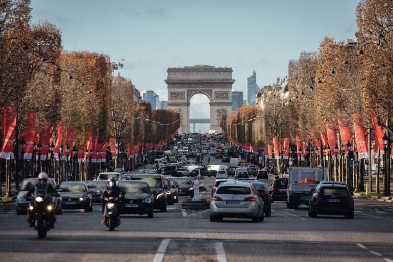 Automobiles drive along the Champs Elysee near the Arc de Triomphe on the Champs Elysee ahead of a new curfew in Paris, France, on Tuesday, Dec. 15, 2020. France eased some of its key lockdown measures, while extending other curbs and introducing a new curfew, as the nation continued its fight to get a grip on the coronavirus. Photographer: Cyril Marcilhacy/Bloomberg via Getty Images