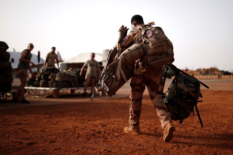 A French soldier leaves with his backpack at the Operational Desert Platform Camp (PfOD) during the Operation Barkhane in Gao