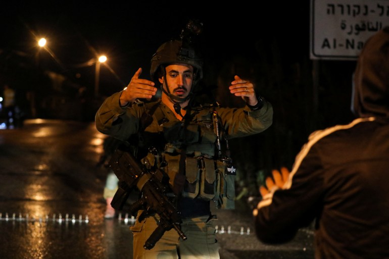Israeli forces gather at the scene of a shooting attack near a Jewish settler outpost, near Nablus