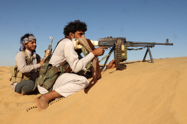 Pro-government tribal fighters take position in a desert area southeast of Marib, Yemen