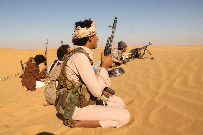 Pro-government tribal fighters take position in a desert area southeast of Marib, Yemen