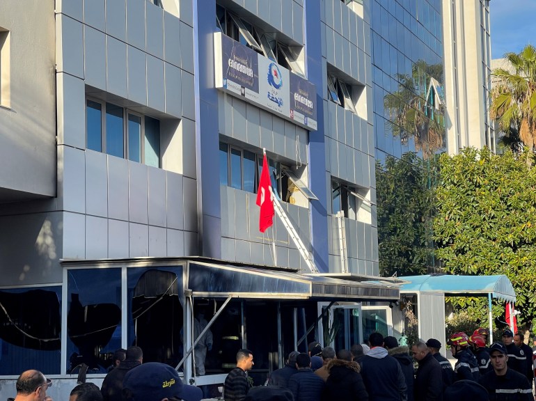 People stand outside the headquarters of Tunisia's Ennahda party in Tunis