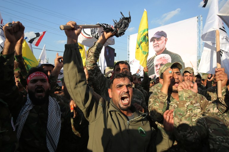 Members of the Hashed al-Shaabi paramilitary force chant anti-US slogans during a protest over the killings of Iranian commander Qassem Soleimani and Iraqi paramilitary commander Abu Mahdi Al-Muhandis, on January 6, 2020 in Karrada in central Baghdad. (Photo by AHMAD AL-RUBAYE / AFP)