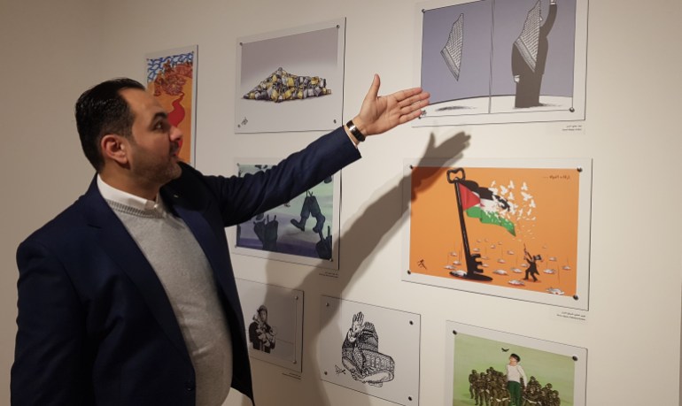 الفنان أسامة نزال أمام لوحة الفنان عماد حجاج - معرض فلسطين وياسر عرفات-فلسطين-رام الله- يناير