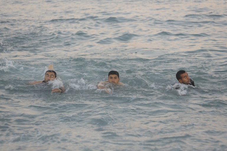 غزة/ الجزيرة/رجال يسبحون في البحر خلال الشتاء.