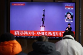 People watch a TV broadcasting file footage of a news report on North Korea firing a ballistic missile off its east coast in Seoul