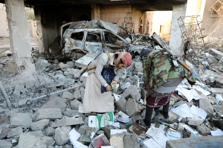 Guards search the rubble of a house hit by Saudi-led air strikes in Sanaa