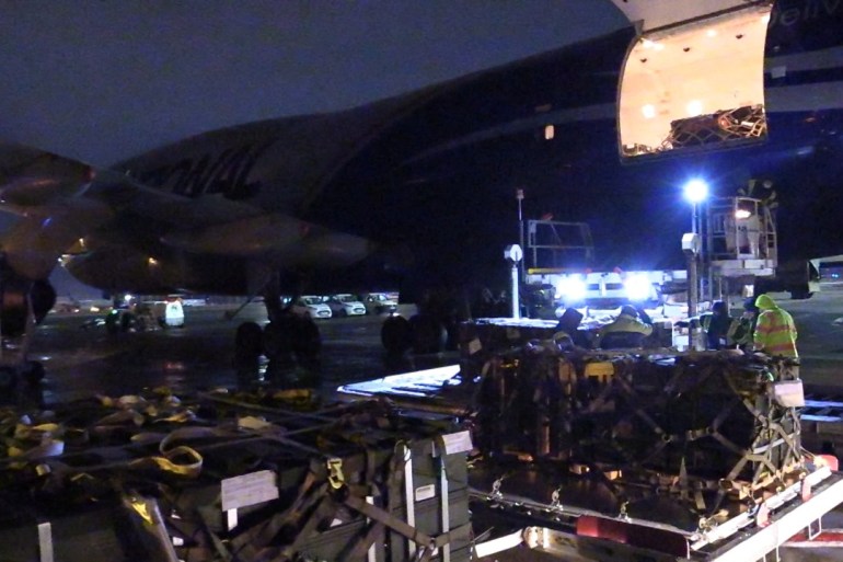 Workers unload a shipment of military aid delivered as part of the United States of America's security assistance to Ukraine, at the Boryspil International Airport outside Kyiv