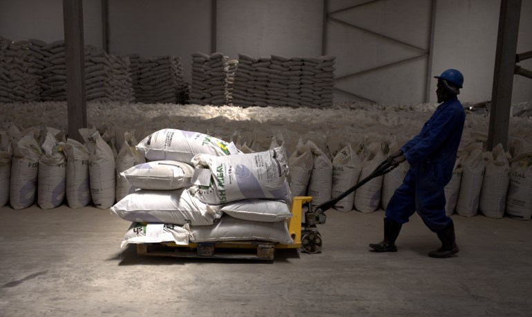 A worker pulls a trolley loaded with sacks of fishmeal produced by the Omaurci SA company in Nouadhibou