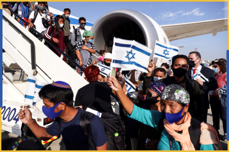 Newly-arrived Jewish immigrants from India wave Israeli flags next to the aircraft at the Ben Gurion airport amid coronavirus disease (COVID-19) restrictions in Lod, Israel October 13, 2021 REUTERS/Ronen Zvulun