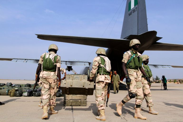Nigerian soldiers prepare to load weapons stored in boxes into a military plane before leaving for Mali, at the airport in Nigeria