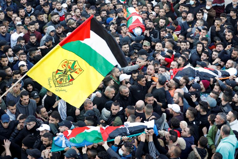 Mourners carry the bodies of three Palestinian gunmen, killed by Israeli forces, during the funeral, in Nablus, in the Israeli-occupied West Bank, February 8, 2022. REUTERS/Raneen Sawafta