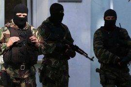 Armed men stand guard in front of the entrance of the Mejlis of the Crimean Tatar people (the single highest executive-representative body of the Crimean Tatars) in Simferopol on September 16, 2014. Russian police on September 16 raided the assembly of pro-Kiev Crimean Tatars, activists told AFP, days after Crimean residents overwhelmingly backed pro-Kremlin parties in polls. Authorities also raided the homes of two Tatar activists in what the leader of the Tatar governing body, the Mejlis, called the start of "direct repressions" against the peninsula's pro-Kiev community. AFP PHOTO / MAX VETROV MAX VETROV / AFP