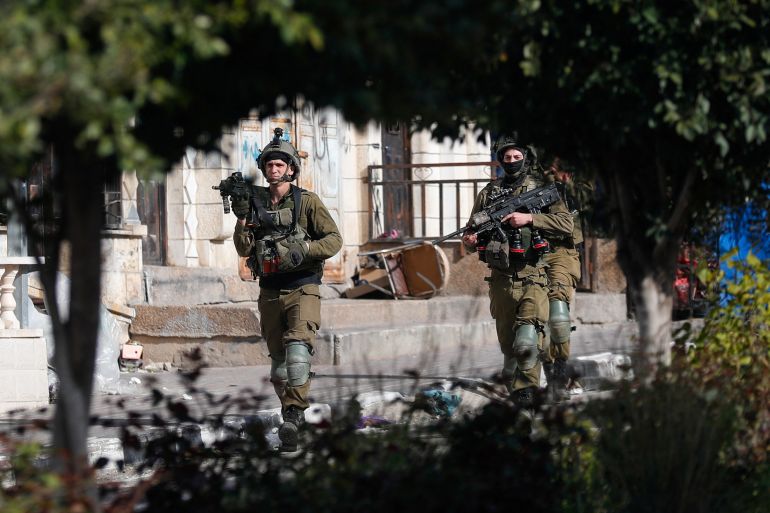 Israeli soldiers walk during a raid in Jenin in the Israeli-occupied West Bank March 30, 2022. REUTERS/Mohamad Torokman 