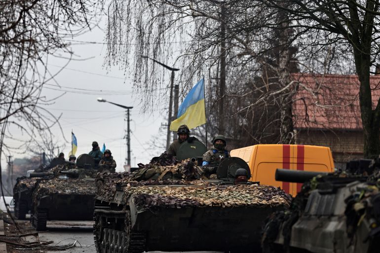 Ukrainian soldiers are pictured on their tanks as they drive along the street, amid Russia's invasion on Ukraine, in Bucha, in Kyiv region
