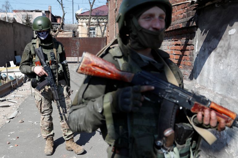 Service members of pro-Russian troops carry out a search of a house in Mariupol