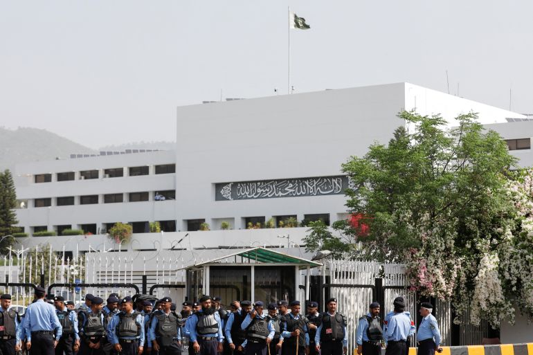 Police officers stand guard outside the parliament building in Islamabad