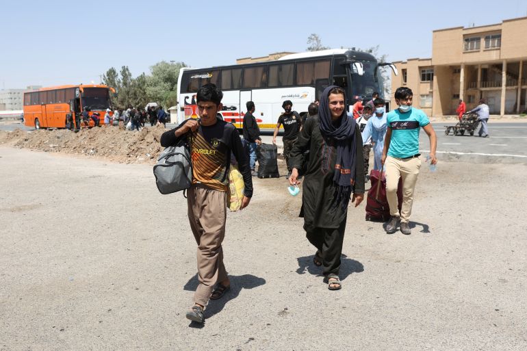 Afghan nationals enter Iran at the Dowqarun border crossing between Iran and Afghanistan