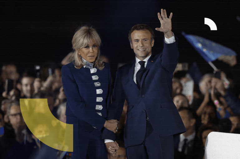 French President Emmanuel Macron waves on stage next to his wife, French first lady Brigitte Macron, after being re-elected as president, following the results in the second round of the 2022 French presidential election, during his victory rally at the Champ de Mars in Paris, France, April 24, 2022. REUTERS/Benoit Tessier