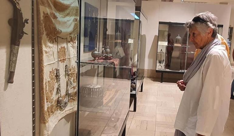 سائحة أجنبية أمام قطع أثرية معروضة في المتحف الوطني العراقي (الجزيرة نت)