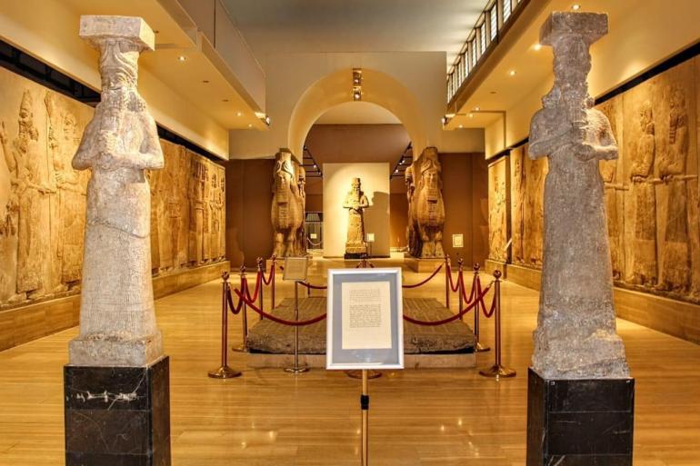 تمثالان بحجم كبير من الرخام من عهد الأشوريين في العراق عند مدخل المتحف الوطني في بغداد (الجزيرة نت)