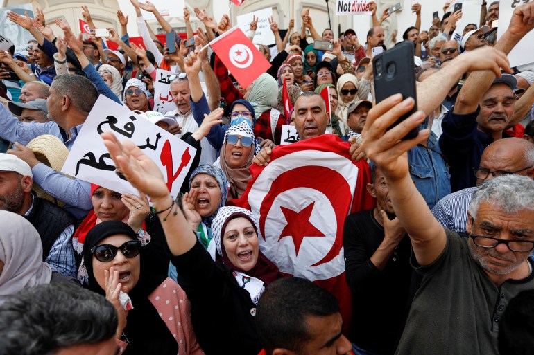 Demonstrators carry banners and flags during a protest against Tunisian President Kais Saied in Tunis, Tunisia May 15, 2022. REUTERS/Zoubeir Souissi
