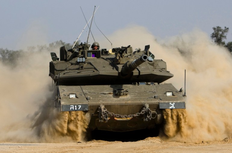 An Israeli Tank maneuvers near kibbutz Kerem Shalom just outside the southern Gaza Strip