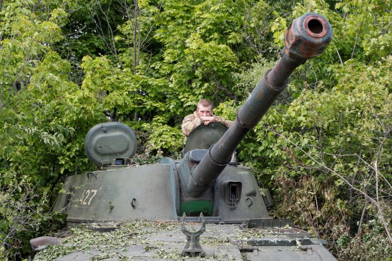 A service member of pro-Russian troops is seen atop a self-propelled howitzer in the Luhansk region