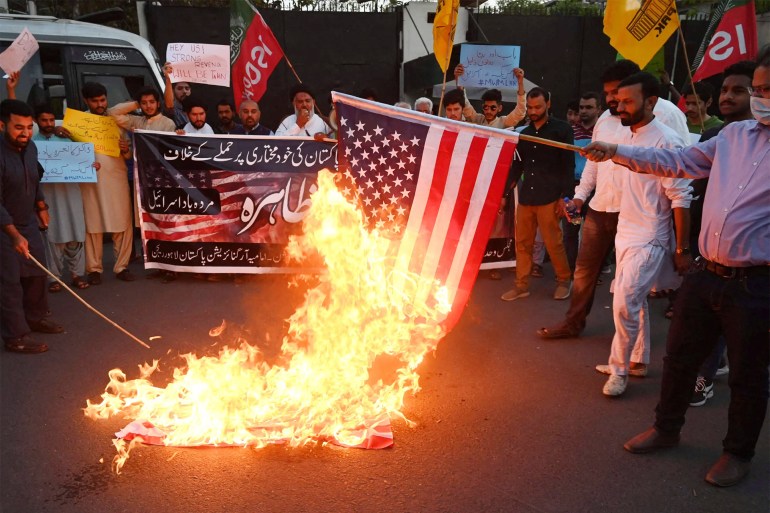 Shiite Muslim demonstrators from Majlis Wahdat-e-Muslimeen Pakistan political organisation burn US flags during an anti-US protest in Lahore April 1, 2022. - Pakistan's Prime Minister Imran Khan on March 31 accused the United States of meddling in Pakistan's politics -- a claim quickly denied by Washington -- as a debate on a no-confidence motion against him in parliament was postponed. (Photo by Arif ALI / AFP) (Photo by ARIF ALI/AFP via Getty Images)