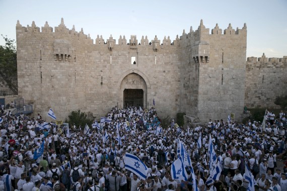مستوطنون يهود يرفعون الأعلام الإسرائيلية قرب البلدة القديمة أمس الجمعة (رويترز)