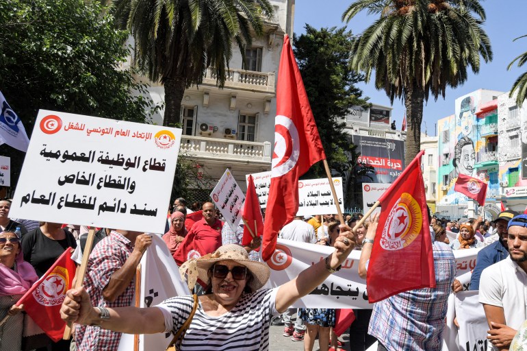 Supporters of the Tunisian General Labour Union (UGTT) gather with national flags during a rally outside its headquarters in the capital Tunis on June 16, 2022, amidst a general strike announced by the UGTT. (Photo by FETHI BELAID / AFP)