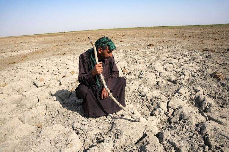 An Iraqi Marsh Arab man looks at a dry ground that was covered with water at the Chebayesh marsh in Dhi Qar