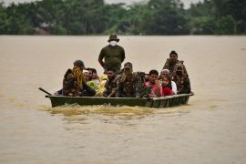 Indian Army soldiers evacuate people from flooded area to a safer place after heavy rains at a village in Hojai district