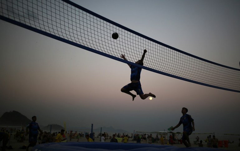 Tourists from Colombia play bossaball 2016 Rio Olympics - Rio de Janeiro, Brazil - 17/08/2016. Tourists from Colombia play bossaball, a combination of volleyball, football and gymnastics, played on an inflatable court featuring a trampoline on each side of the net, on Copacabana beach. REUTERS/Nacho Doce