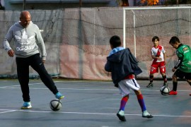 Uruguay's former soccer player Jose Batista kicks the ball, as he teaches soccer to kids, at a club where he works before an interview with Reuters in Buenos Aires