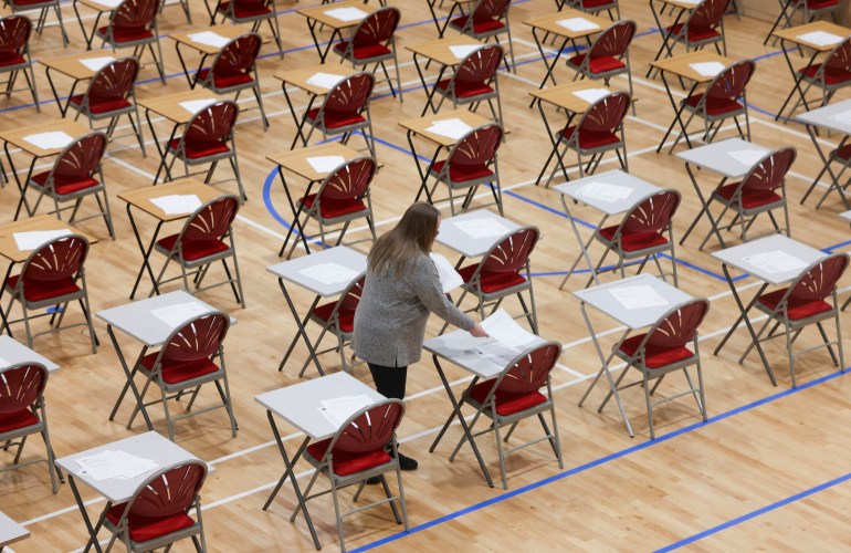 A teacher lays out exams at The Fulham Boys School on the first day after the Christmas holidays following a government announcement that face masks are to be worn in English secondary schools amid the coronavirus disease (COVID-19) outbreak in London, Britain, January 4, 2022. REUTERS/Kevin Coombs