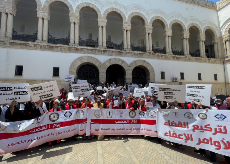 Tunisian judges carry banners during a protest in Tunis