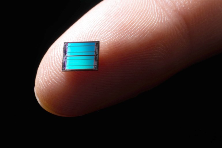 0Blue Computer Chip on Tip of Index Finger - stock photo Blue Colored Computer Chip on Tip of Index Finger Against Dark Black Background Extreme Close-up View, Macro Photo. gettyimages-1182272277