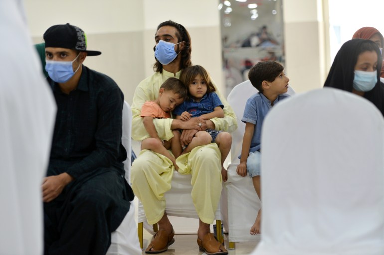 Massoud and his children wait at the Afghan evacuee centre, as thousands of people are processed at the Emirates Humanitarian city in Abu Dhabi, UAE, August 28, 2021. REUTERS/Vidhyaa Chandramohan
