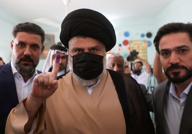 Iraqi Shi'ite cleric Muqtada al-Sadr shows his inked finger after voting at a polling station in Najaf, as Iraqis go to the polls to vote in the parliamentary election, in Iraq, October 10, 2021. REUTERS/Alaa Al-Marjani TPX IMAGES OF THE DAY