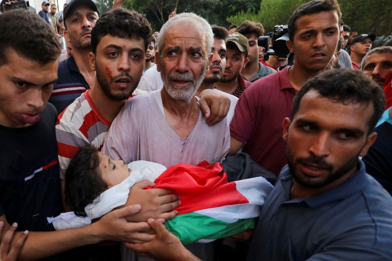 SENSITIVE MATERIAL. THIS IMAGE MAY OFFEND OR DISTURB The grandfather of Palestinian girl Alaa Qadoum carries her body in Gaza City August 5, 2022. REUTERS/Ashraf Amra NO RESALES. NO ARCHIVES TPX IMAGES OF THE DAY
