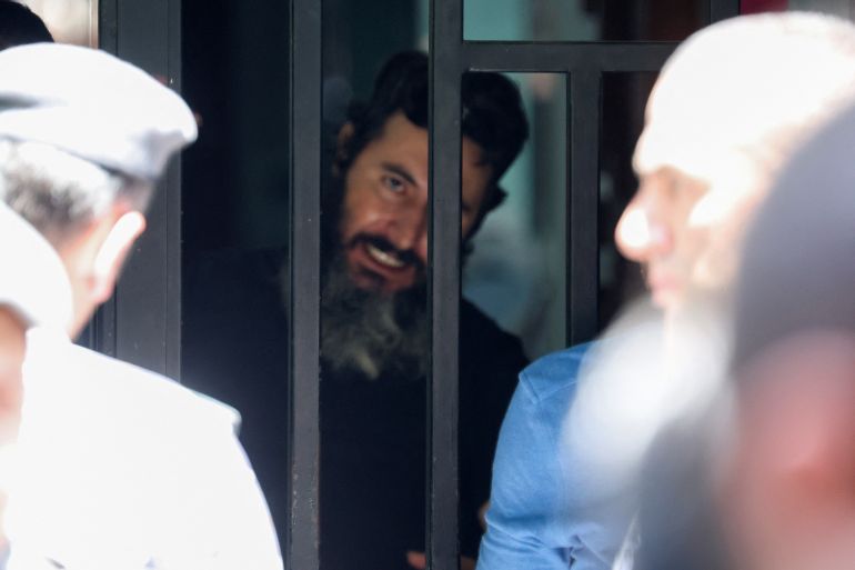 A man who security sources said is armed and holding hostages is seen through the door of the Federal Bank of Lebanon in Hamra