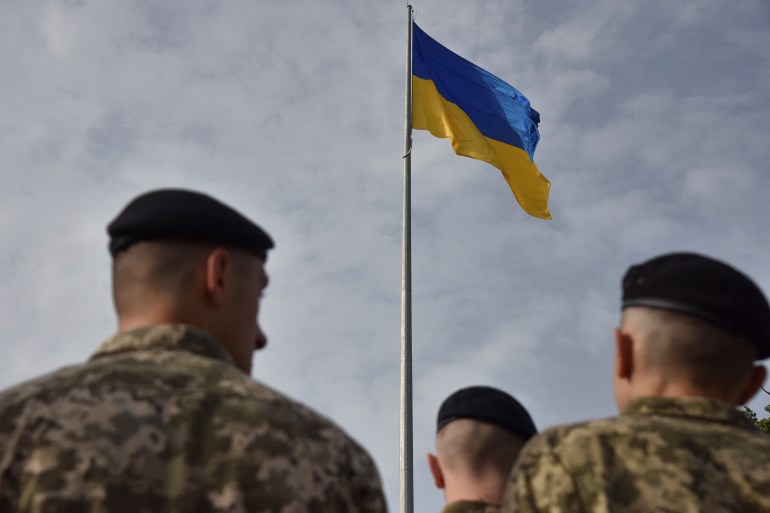 Ukrainian service members attend a rising ceremony of the Ukraine's national flag to mark the Day of the State Flag in Lviv